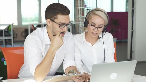 Deux collègues sont assis à discuter au travail en souriant