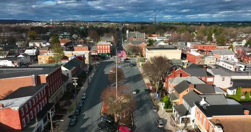 Anytown USA on bright sunny day under dramatic clouds and sky. Town square with businesses and car t