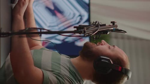 Man with Headphones Speaking into Microphone Indoors