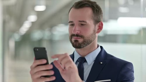 Man Using Smartphone in Corporate Setting Close Up