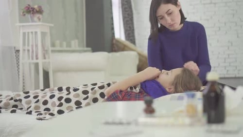 Adult Woman Caring for Sick Girl on Bed