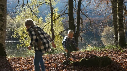 Happy Children Play in the Autumn Park. Boy and Girl Throw and Play a Fallen Leaf.