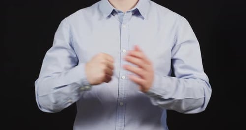 Man rubbing knuckles in light blue shirt