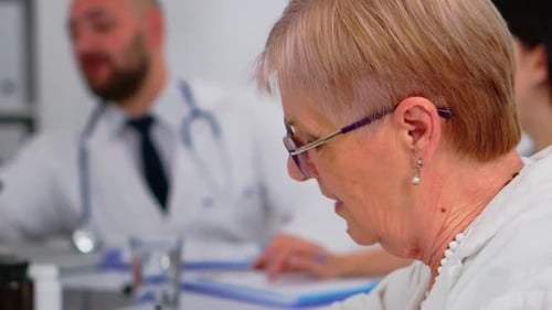 Close Up of Senior Woman Doctor Talking with Colleague