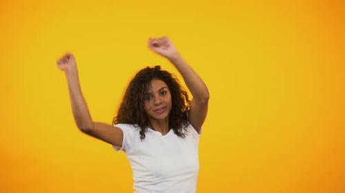 Woman Dancing Joyfully on Yellow Background