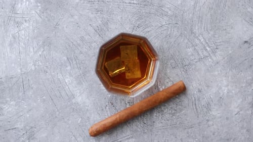 Glass of Liquor and Cigar on Gray Surface