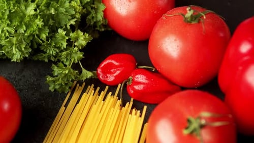 Tomatoes with Parsley and Pasta on a Black Background