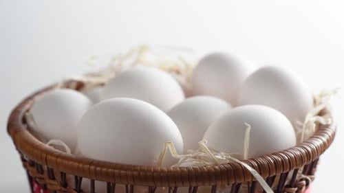 Close-up of a basket with white chicken eggs.