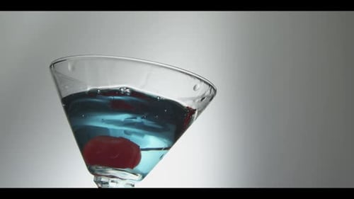 Vibrant Blue Cocktail and Red Cherry in Glass