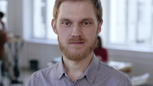 Close-up Portrait of Young Successful Caucasian Businessman Looking at Camera Serious, Then Smiling