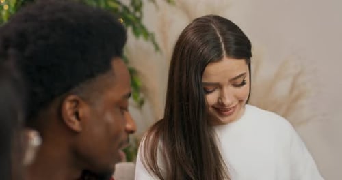 Woman Opens a Christmas Gift with a Friend