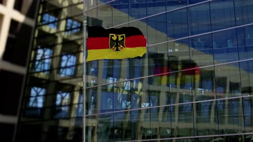 Waving German Flag on Pole Against Modern Corporate Building
