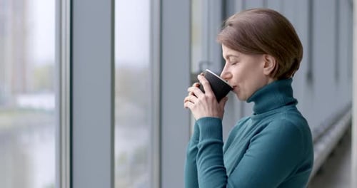 Woman Drinking Coffee in a Bright Urban Space