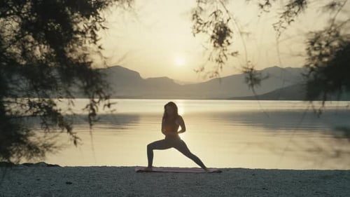 Girl Practices Yoga at Sunset By the Ocean