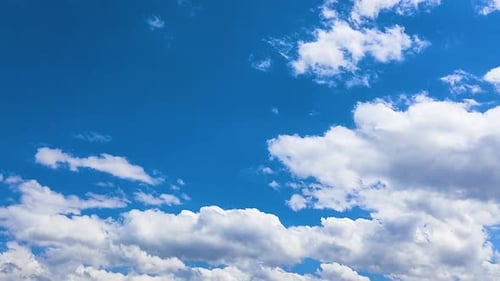 Fluffy Clouds Moving Across Vivid Blue Sky