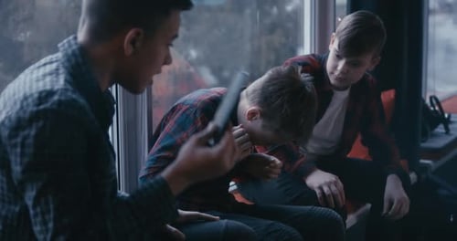 Teens Comforting Friend Holding Tablet Indoors