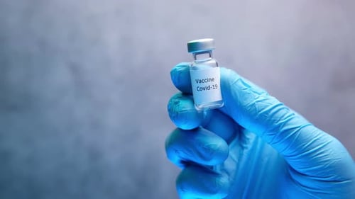 Doctor Hand in Gloves Holding Coronavirus Vaccine, Close Up
