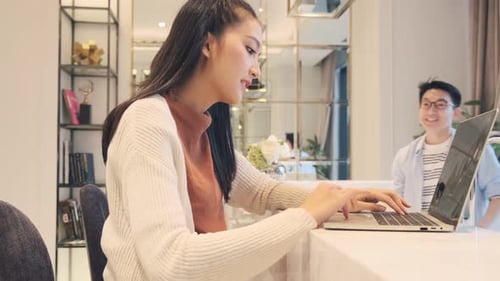 Woman Working on Laptop at Home, Receiving Drink