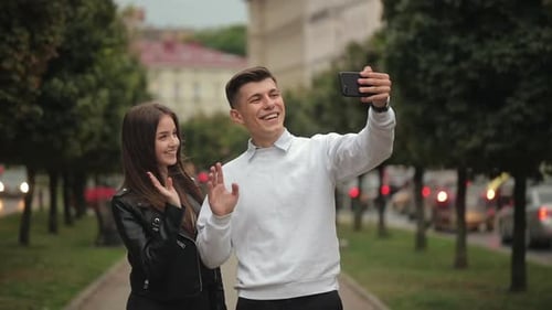 Couple Takes Selfie on City Sidewalk