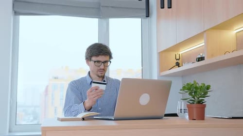Man holds a credit card in his hand, online shopping in stores, pays taxes with a credit card online