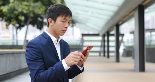 Young Man Using Smartphone in City Street