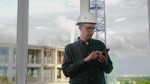 Engineer Using Mobile Phone in Helmet