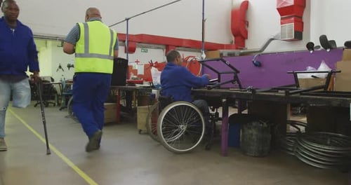 Men working in wheelchair repair factory