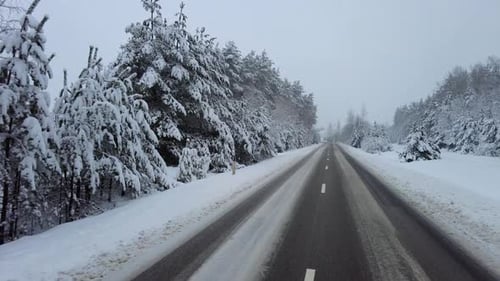 Mit dem Auto auf einer verschneiten Waldstraße
