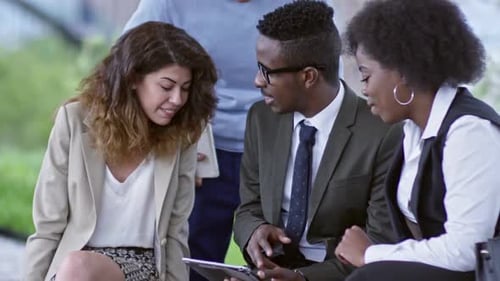 Joyous Colleagues Watching Something on Tablet Outdoors