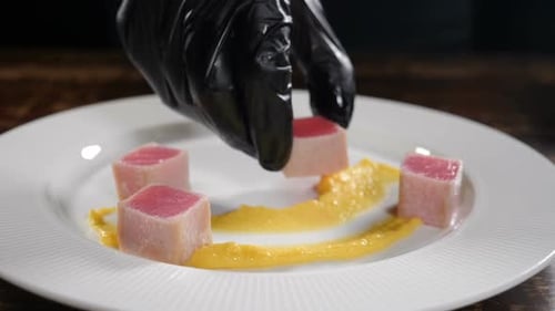 Chef Prepares Dish of Cubed Meat with Sauce