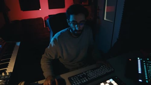 Young adult produces music in home studio