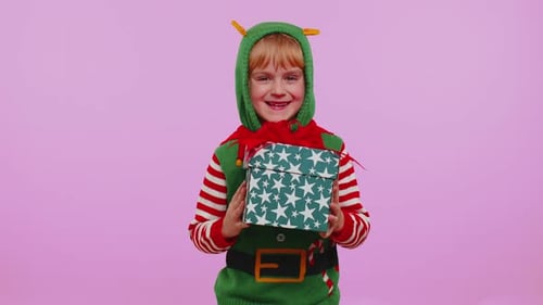 Excited Child Receives Christmas Gift in Elf Costume