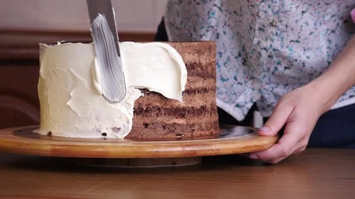 Icing Chocolate Cake on a Wooden Stand