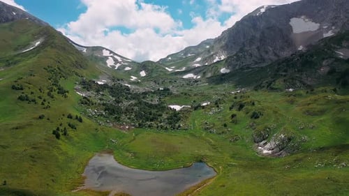 Flying Up Forward Over Beautiful Slope of Caucasian Snow Mountain with Small Forest, Stones Under