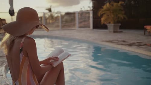Woman Reading by Tropical Pool at Sunset