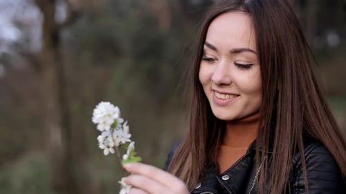 Woman Smiling at Flowers Outside on Spring Day
