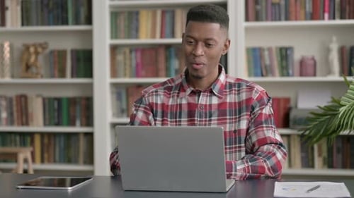 African Man Talking on Video Call on Laptop in Office