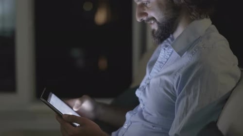 Man Using Tablet Computer Late at Night