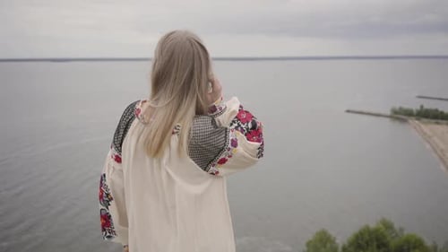 Rear View at Carefree Caucasian Woman Wearing Long Summer Fashion Dress Standing on the Field