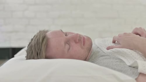 Homme se réveillant et sortant du lit