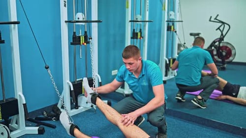Man Does Leg Exercise on Cable Pulley Machine