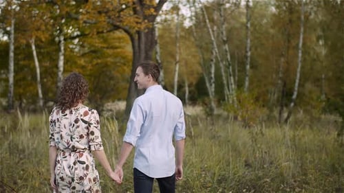 Young Couple Walking on a Meadow