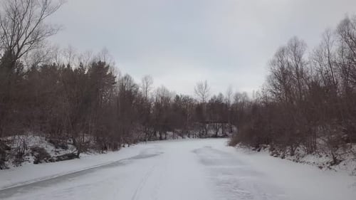 Winter im Wald, Kamera fliegt tagsüber über gefrorenen Fluss