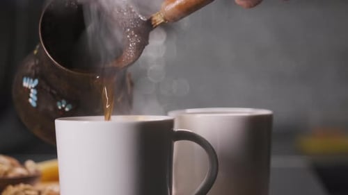 Pouring Steaming Coffee into Mugs