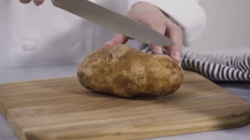Step by step. Slicing russet potatoes in wedges with olive oil and spices to bake in the oven.