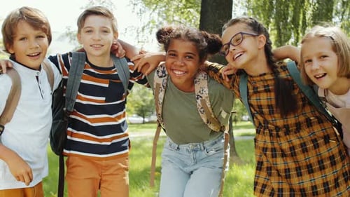 Smiling School Children Group Embrace in Sunny Park