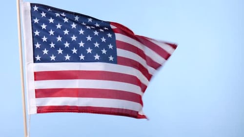 American Flag Waving Against Light Blue Sky