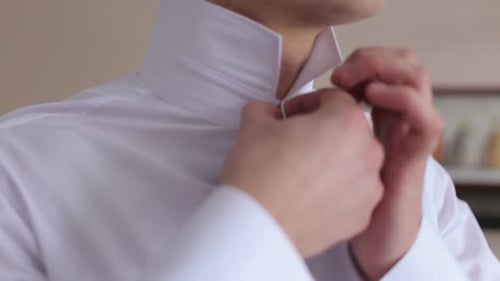 Young Adult Buttoning a Dress Shirt Collar