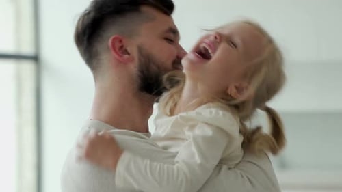 Loving Father Holding Laughing Daughter in Embrace