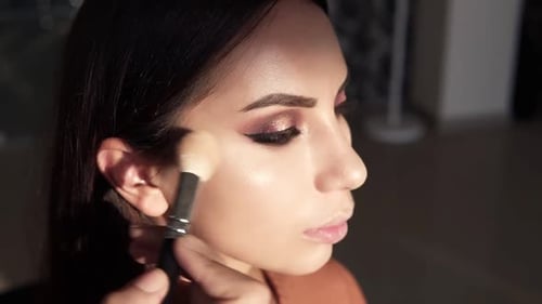 Woman Getting Makeup Applied with Brush Indoors